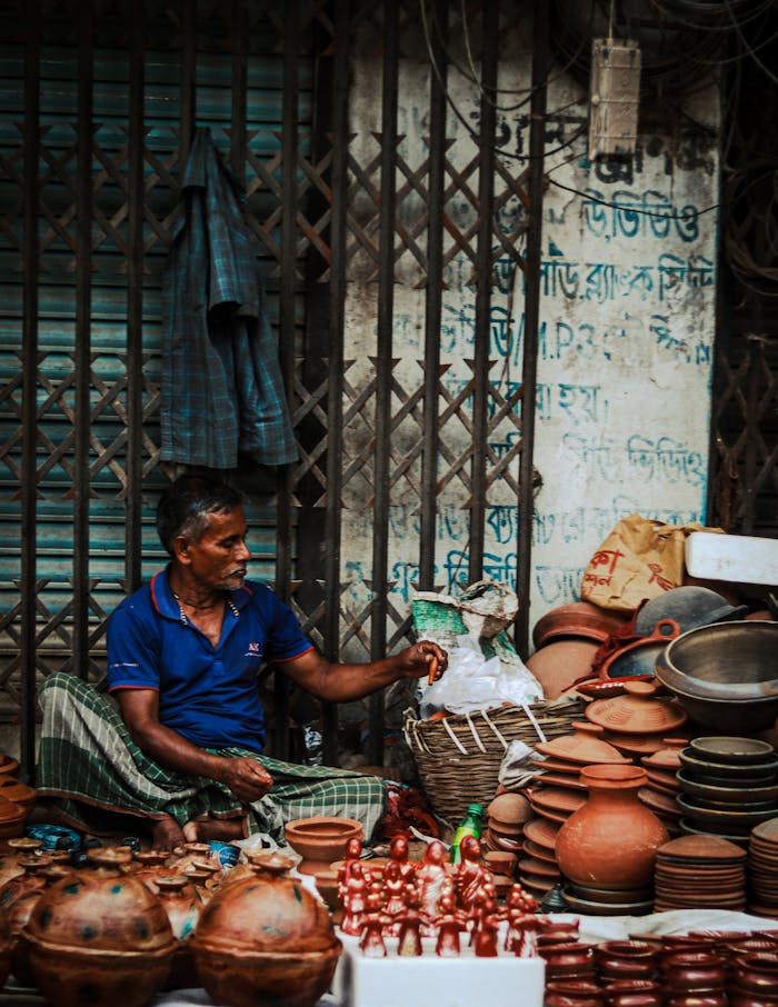 A man selling traditional clay pottery and figurines on the streets of Bangladesh.